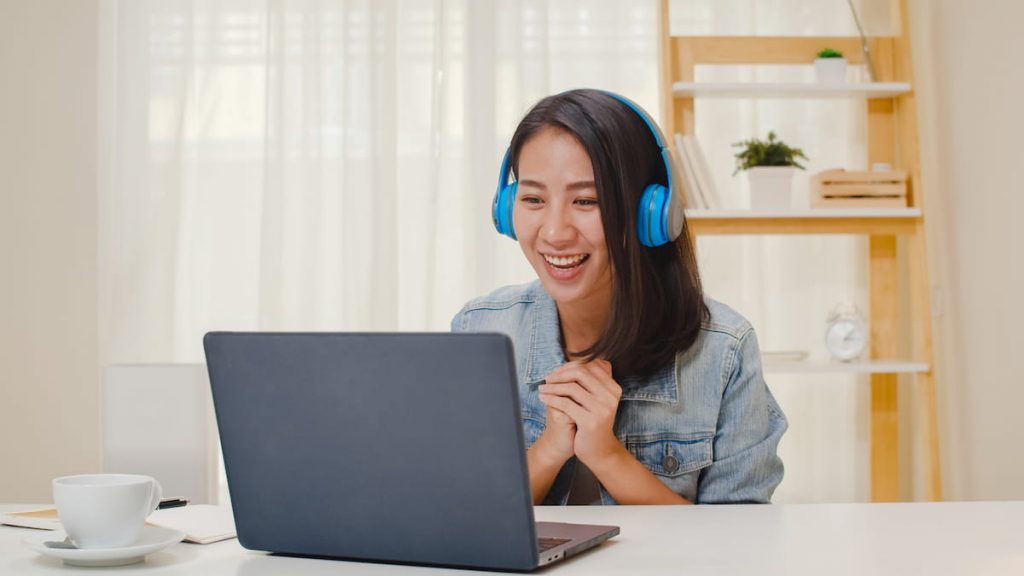 Girl smiling at her laptop during online training.