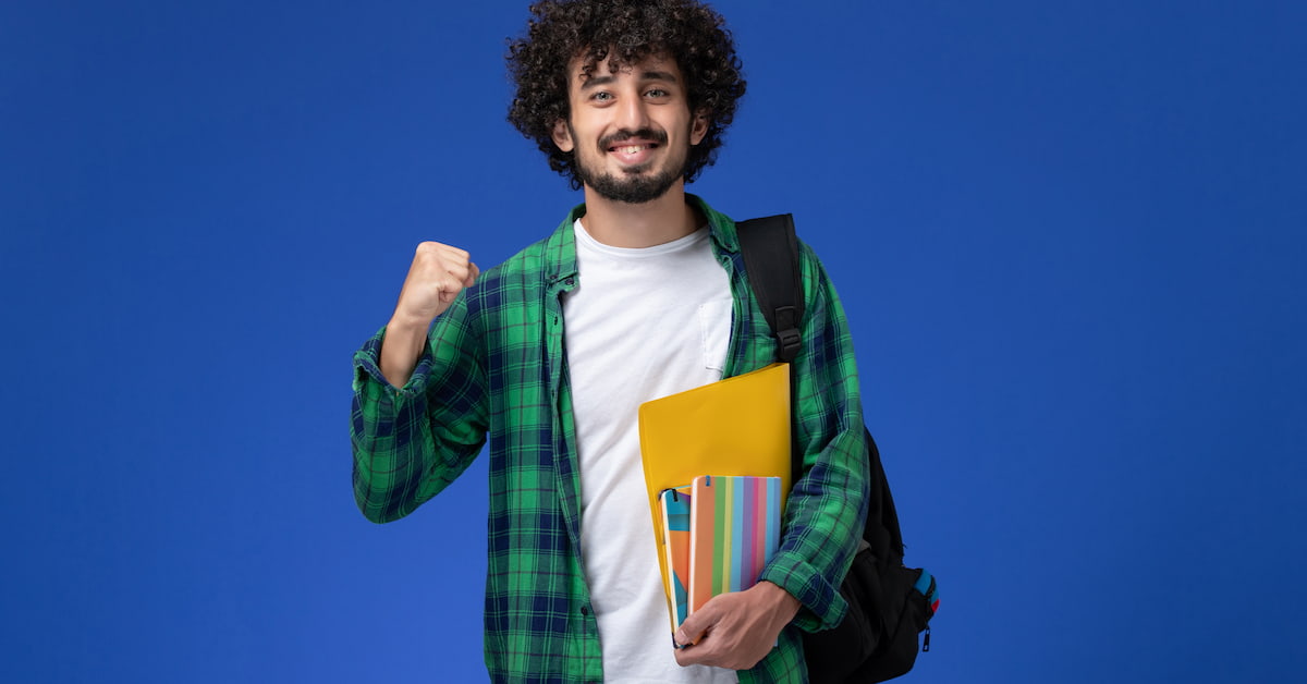 Happy young man holding books.