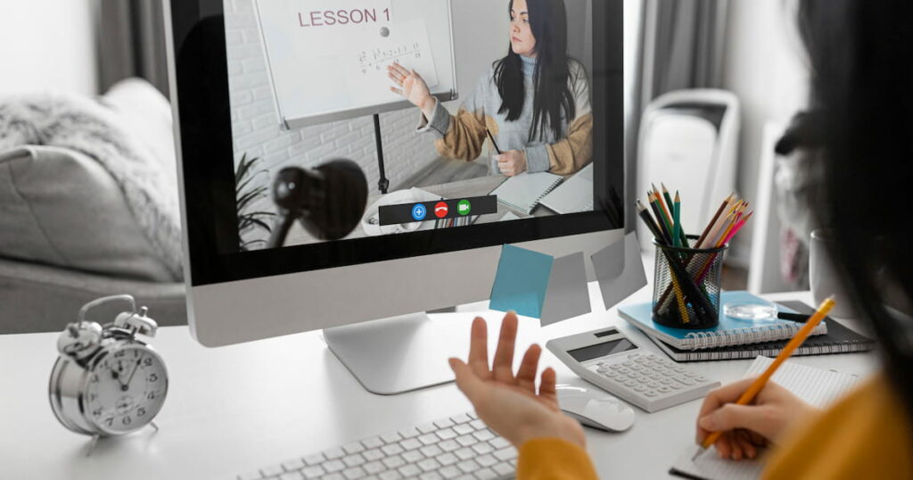 Image of a computer screen with someone at the front as they learn English online