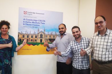 Students And Tutor With Cambridge Banner
